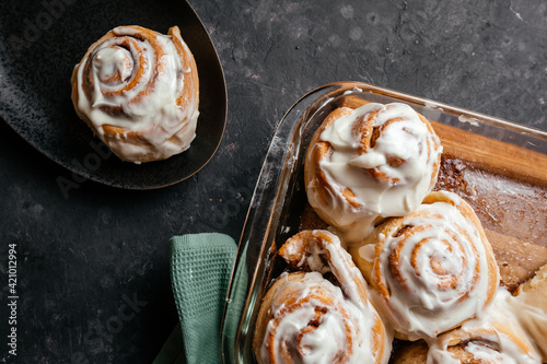 Cinnamon sinnabon bun, with vanilla fudge on a dark background. photo