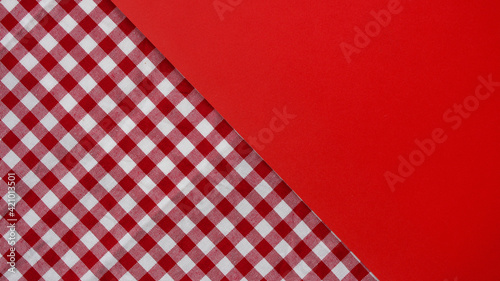 Colored background. Red checkered tablecloth and red background. Traditional American country tablecloth.