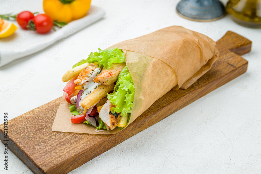 Gyros with chicken on the board on white concrete table Greek cuisine Gyros with chicken on the board on white concrete table Greek cuisine