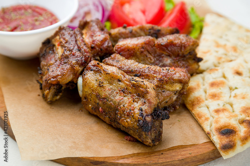 skewers of pork ribs with vegetables, pita and totamo sause