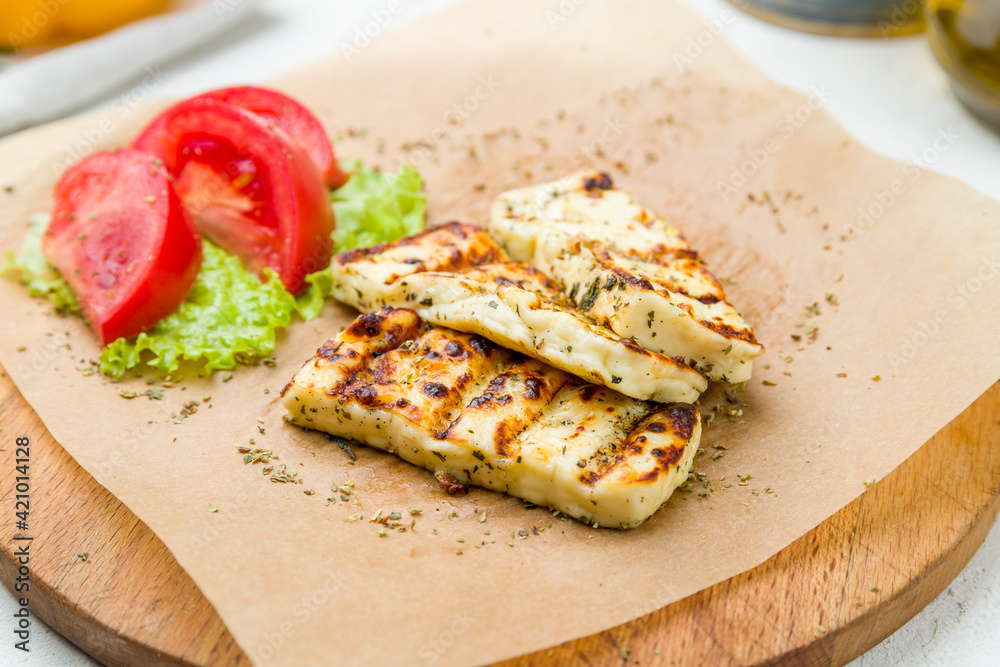 grilled halloumi cheese with vegetables on board on white concrete table grilled halloumi cheese with vegetables on board on white concrete table