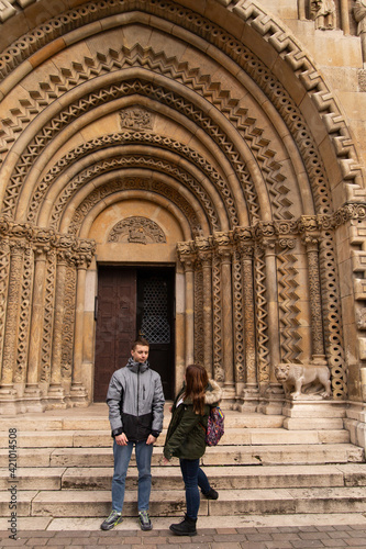 A group of people travels across Europe. Travel to Hungary, European tour. Tourists - a guy with a girl near an old building are talking emotionally. © Nona Liuter