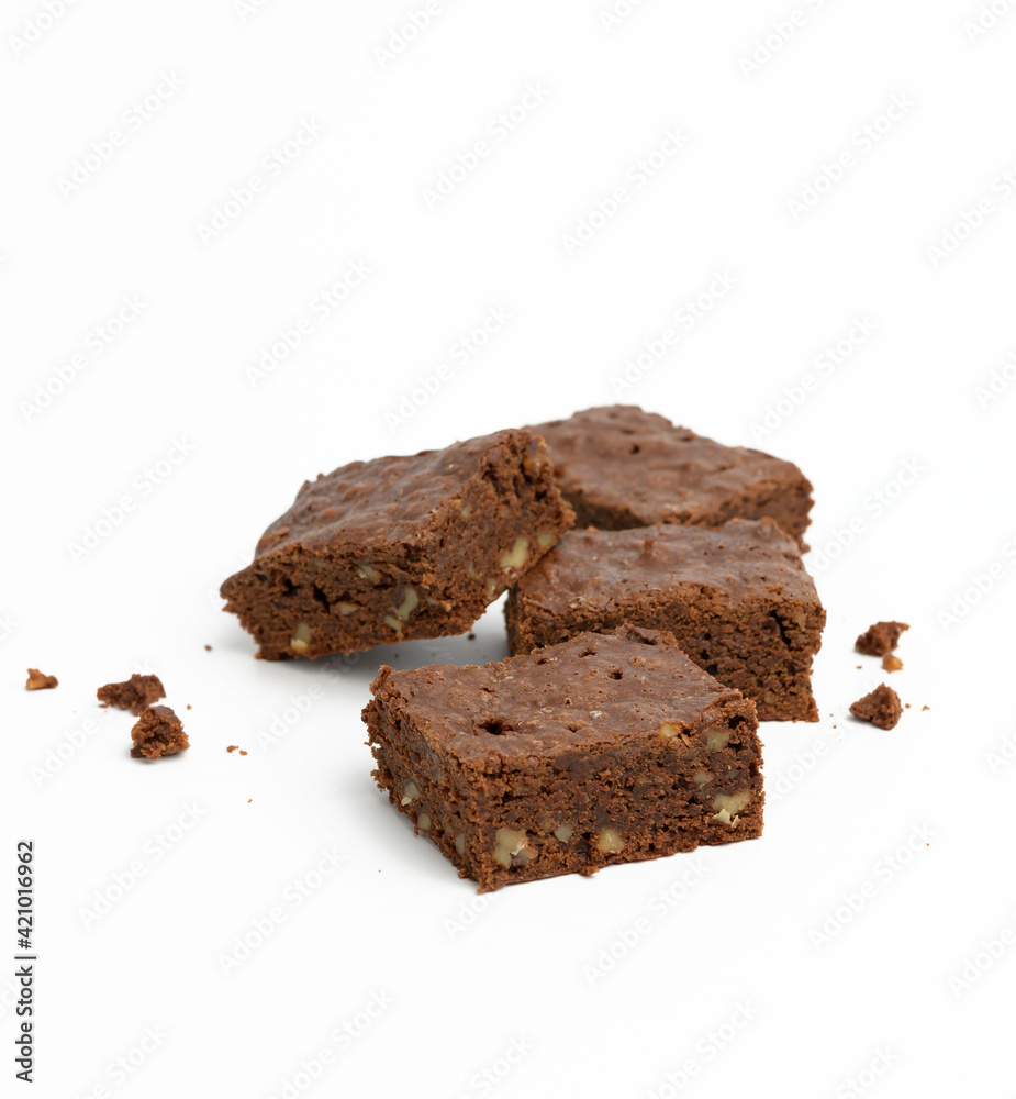 baked chocolate brownie pieces with walnut on white background, delicious dessert