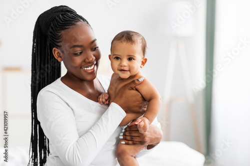 African American mom hugging her cute infant and posing photo