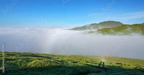 Distant views of the mountain summits of Meall Garbh, Ben Lawers, Beinn Ghlas and Meall Corranaich from below the top of Carn Mairg with Glen Lyon below in the Scottish Highlands, UK landscapes. photo