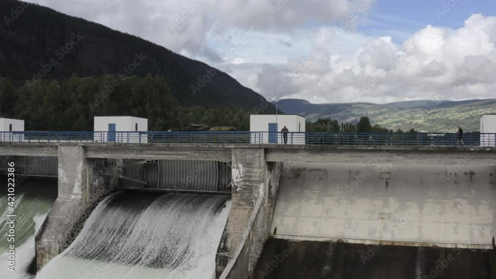 Man Watching Water Flowing Through Hydroelectric Dam Man Watching Water Flowing Through Hydroelectric Dam