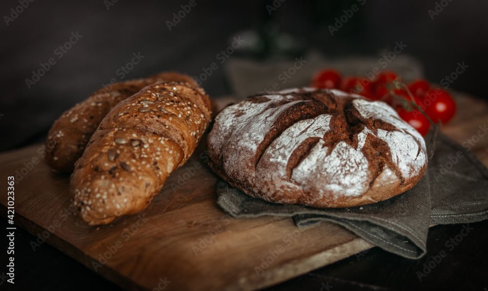 Fresh baked bread on dark wooden background.