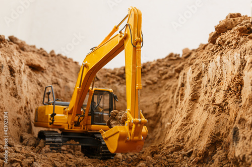Selective focus ,bucket of excavators are digging the soil in the construction site with on white background