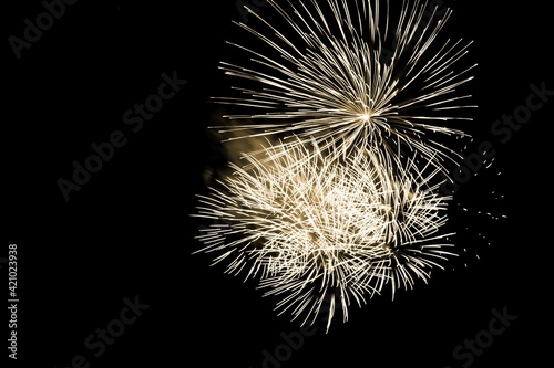 Luxury fireworks event sky show with yellow big bang stars. Premium entertainment magic star firework at e.g. New Years Eve or Independence Day party celebration. Black dark night background