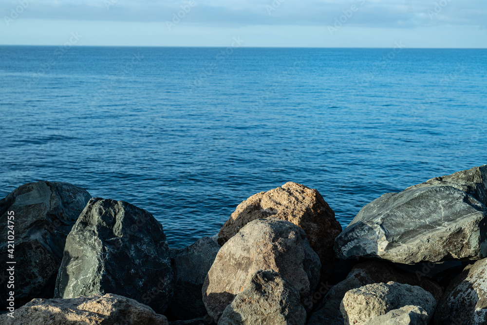 Steinküste Gran Canaria bei Sonnenaufgang und ruhiger See mit leichtem Wellengang Steinküste Gran Canaria bei Sonnenaufgang und ruhiger See mit leichtem Wellengang