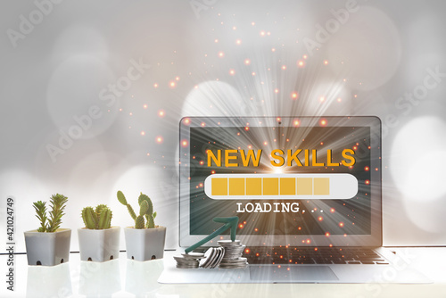 New skills loading with stack of coins and arrow upward on computer laptop on desk. Reskilling and upskilling concept and modern technology machine learning idea