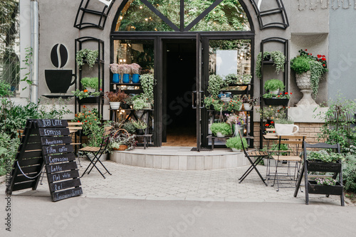 Fototapeta Naklejka Na Ścianę i Meble -  Eco cafe on street and flower studio, small business in city, reopening after covid-19, outdoor interior