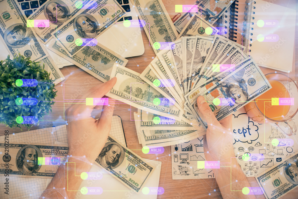 Multi exposure of technology drawing hologram and us dollars bills and man hands. Data concept Multi exposure of technology drawing hologram and us dollars bills and man hands. Data concept