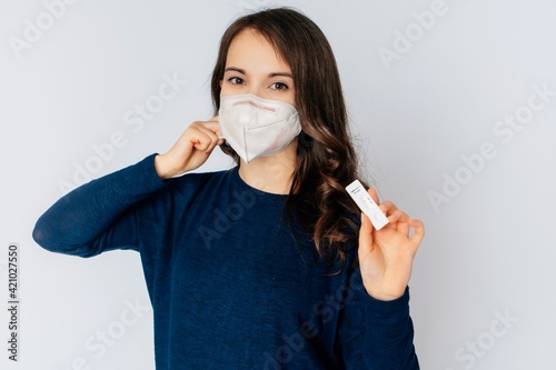 beautiful young woman wearing an anti viurs protection ffp2-mask to prevent from corona covid-19 and sars cov 2 infection white background copy space test kid photo