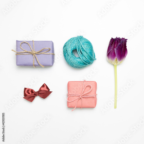 Gift boxes, string, tulip flower, ribbon on white background. flat lay, top view, copy space