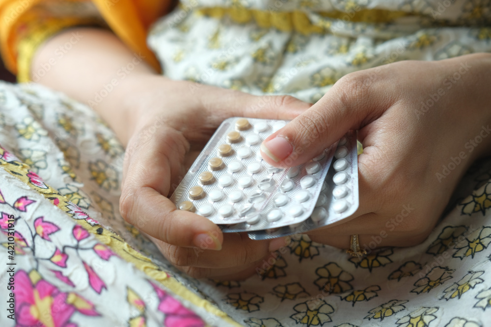 women hand golding birth control pills close up  - obrazy, fototapety, plakaty 