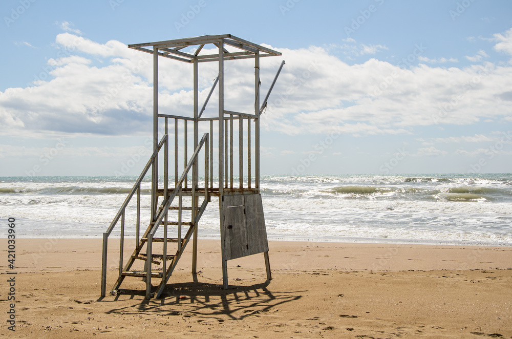 Empty old lifeguard tower on the beach on a cloudy day. Security on public and private beaches.