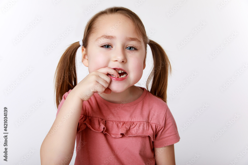 Girl showing first swinging baby tooth