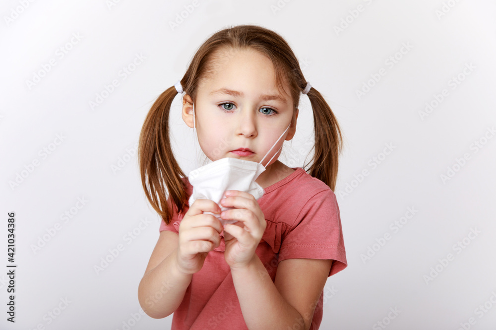 Girl taking away a medical mask to breathe better Girl taking away a medical mask to breathe better