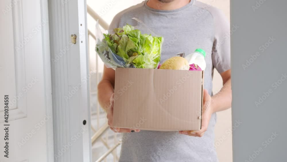 Delivery. Large cardboard box with ordered fresh vegetables and foods closeup.