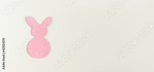 Easter pink paper bunny on the white background. Banner size.
