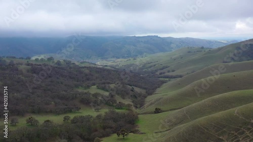 Clouds drift across peaceful green hills and valleys in the tri-valley area in Northern California. This beautiful region is known for its productive vineyards and farms. photo