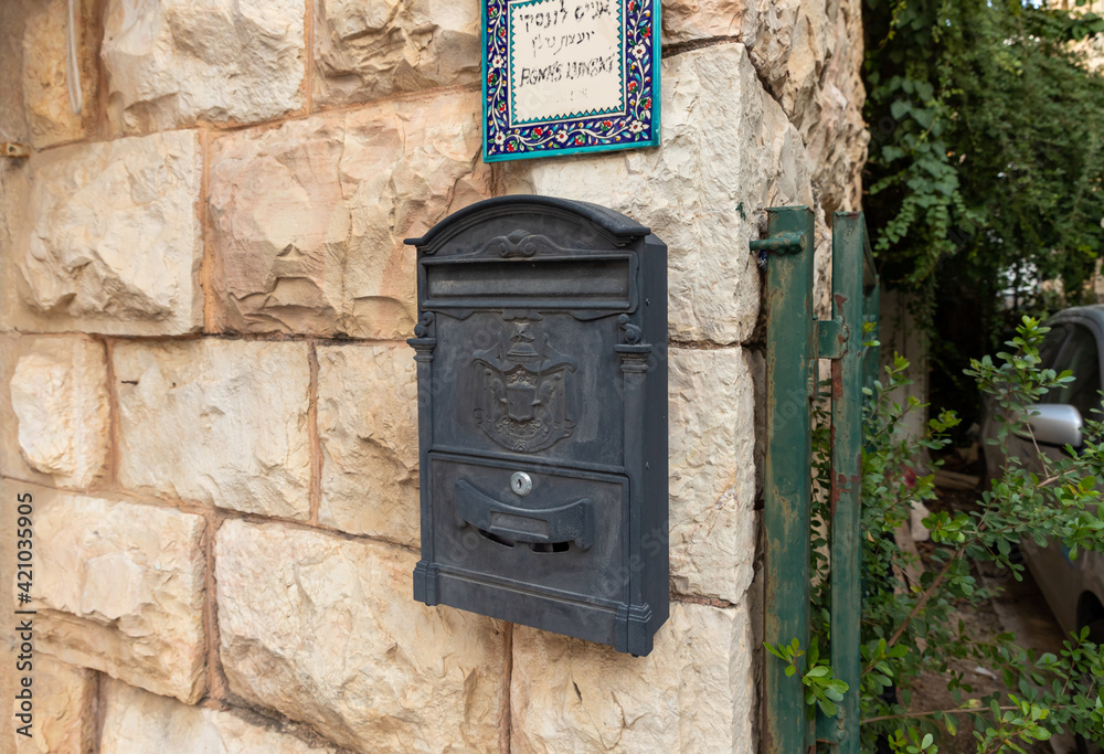 Evening view of old metal mailbox with coat of arms of Jerusalem, hangs on wall of apartment building on a Yehuda Alkalai Street in the old district of Jerusalem Talbia - Komiyut in Jerusalem, Israel Evening view of old metal mailbox with coat of arms of Jerusalem, hangs on wall of apartment building on a Yehuda Alkalai Street in the old district of Jerusalem Talbia - Komiyut in Jerusalem, Israel