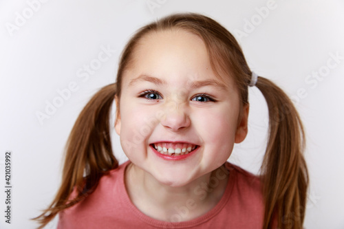 Little funny emotional girl with an open smile