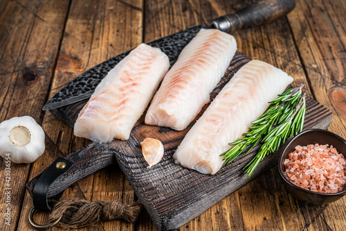 Fotomurale Fresh Raw cod loin fillet steaks on wooden board with butcher knife