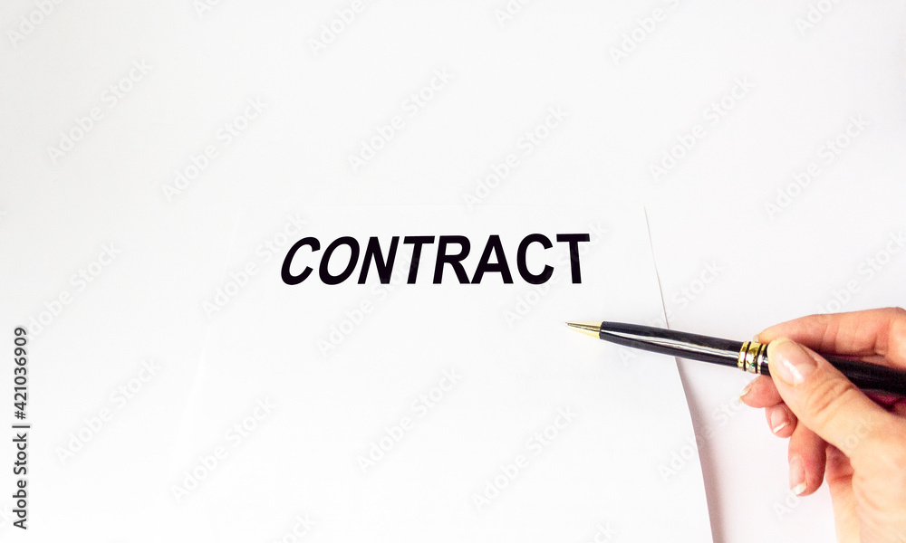A businessman's hand with a pen filling out personal information on a form. the contract A businessman's hand with a pen filling out personal information on a form. the contract