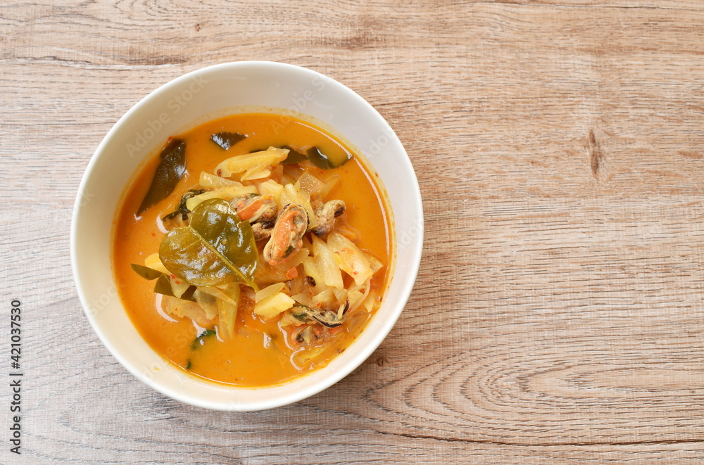 spicy boiled mussel with pineapple and lemon leaf in coconut milk curry soup on bowl spicy boiled mussel with pineapple and lemon leaf in coconut milk curry soup on bowl
