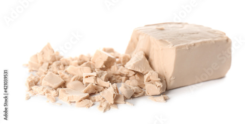 Crumbled block of compressed yeast on white background