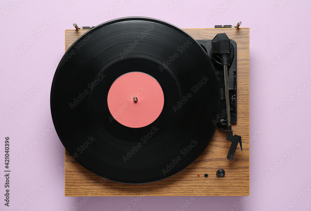 Fototapeta premium Modern turntable with vinyl record on light background, top view