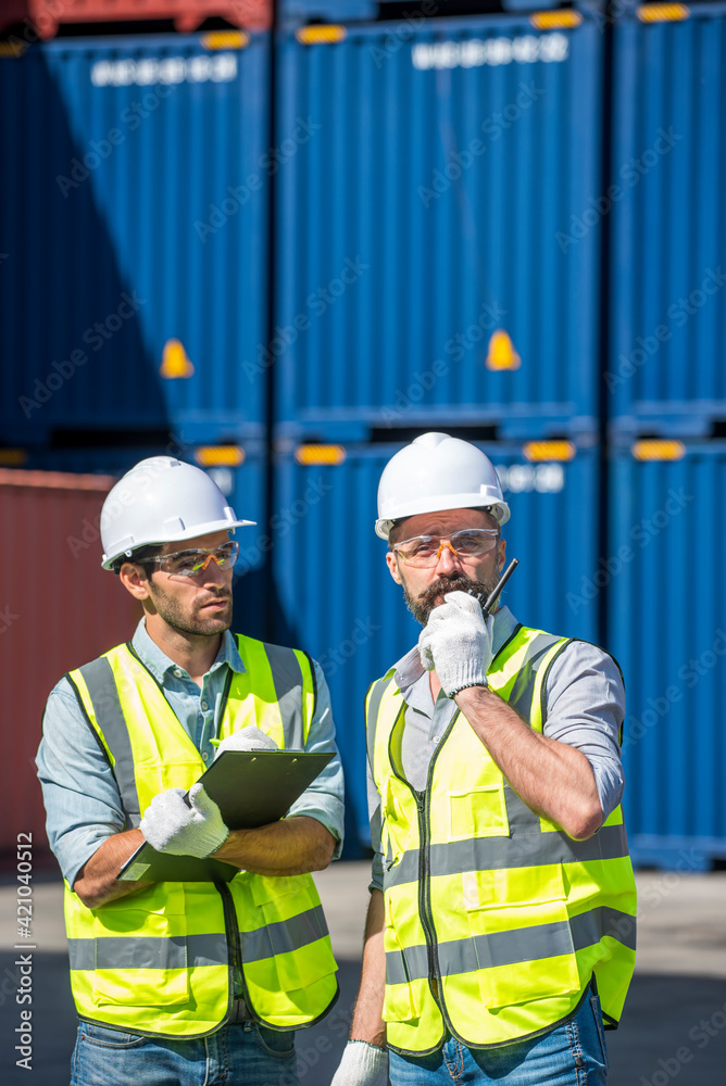 Logistics engineer and inspector working togetter and discussing in shipping containerin commercial transport port Logistics engineer and inspector working togetter and discussing in shipping containerin commercial transport port