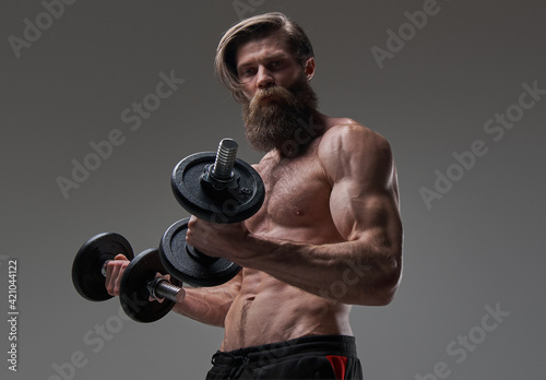 Healthy lifestyle of a sportsman with bearded face and dumbells