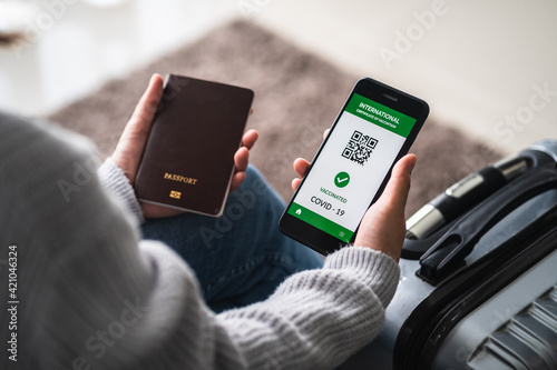 close up of view hands women holding smartphone display on app mobile vaccinated COVID-19 or coronavirus certificate, immunity vaccine passport, new normal travel of tourist concept.