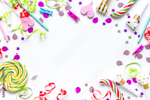 Colored party sweets and confetti on white background top view mockup