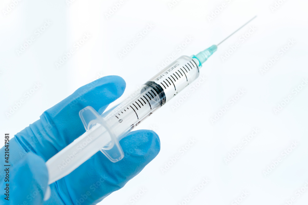 Close up vaccines fight against virus, doctor or scientist in laboratory holding a syringe with liquid vaccines. Close up vaccines fight against virus, doctor or scientist in laboratory holding a syringe with liquid vaccines.