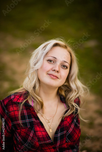 blonde girl in red shirt in nature, selective focus