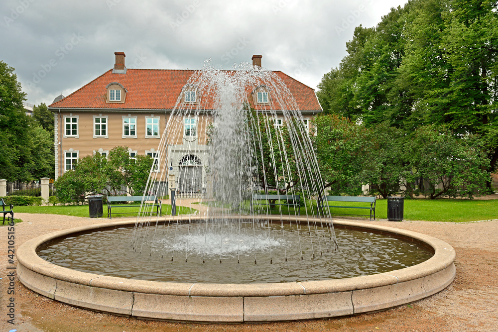 City landscape with fountain in old park on gloomy day. Oslo, Norway