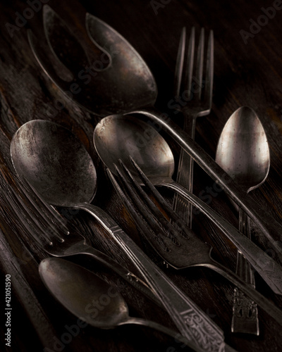 A group of old silverware on aged wood planks.
