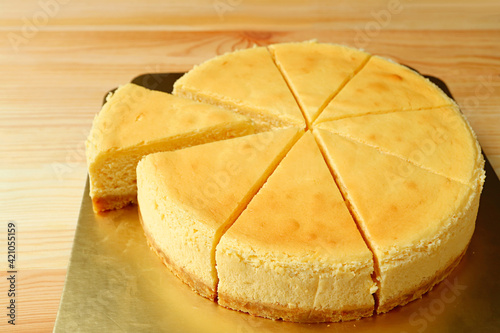Delectable creamy baked cheesecake with a slice cut from whole cake