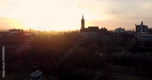 Flying in spring at sunset over the Kelvingrove park in Glasgow, Scotland towards the Gilbert Scott tower at Glasgow University. photo