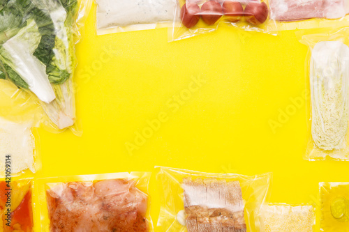 Hands holding bags of food. Salad dinner set: chicken, lettuce, tomatoes, peking cabbage, cheese, bacon, bread, olive oil. A set for delivering food for dinner on a yellow background. photo