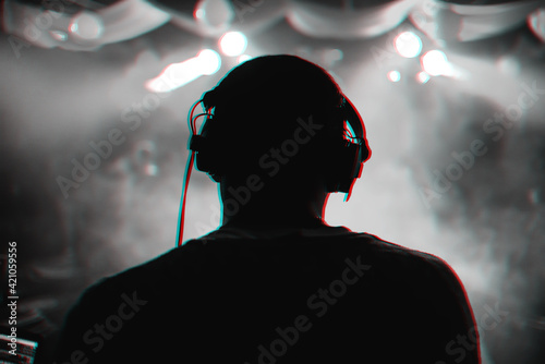 DJ with headphones performs at a music concert
