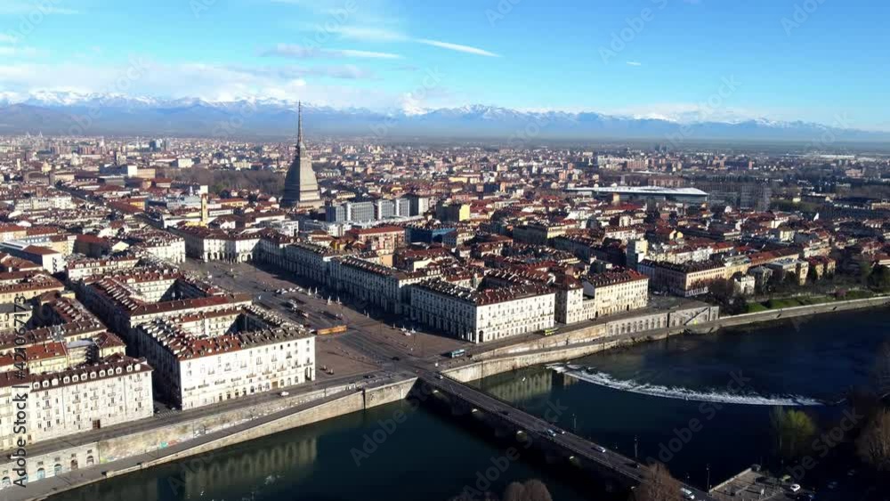 Aerial view of Turin city center, in Italy, in a sunny day, with Mole Antonelliana and Alps in the background. Aerial view of Turin city center, in Italy, in a sunny day, with Mole Antonelliana and Alps in the background.
