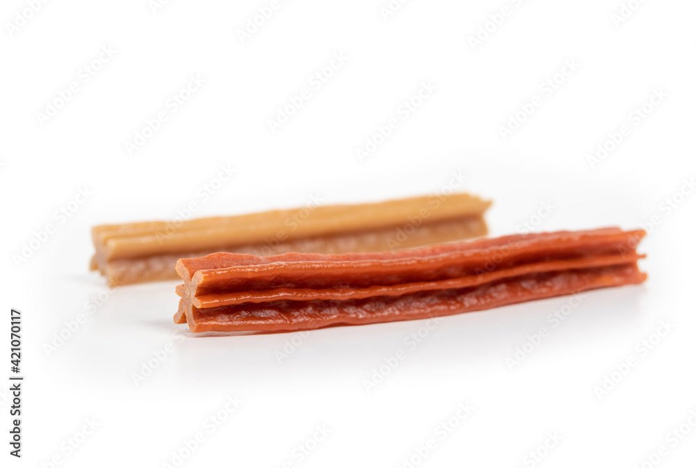 Dog dental chew sticks, perspective view. Two vegetarian and grain free dog treat sticks for stronger teeth, better gums and breath. Dental health treats for dogs. Isolated on white. Selective focus. Dog dental chew sticks, perspective view. Two vegetarian and grain free dog treat sticks for stronger teeth, better gums and breath. Dental health treats for dogs. Isolated on white. Selective focus.