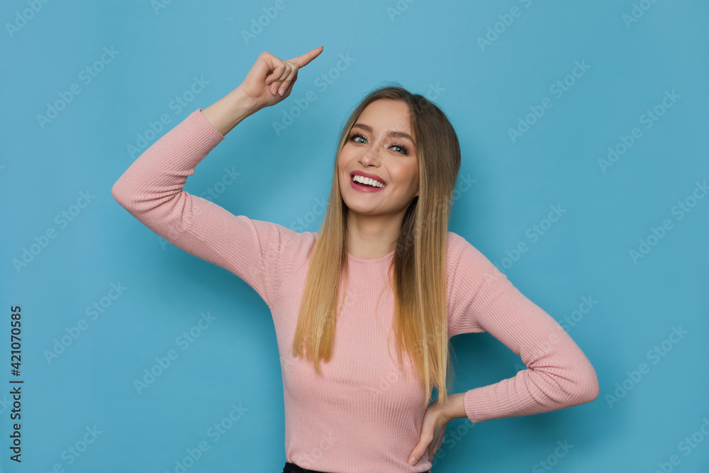 Fototapeta premium Happy Young Woman Is Pointing Over Head