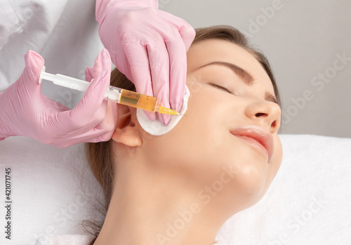 Cosmetologist does prp therapy on the face of a beautiful woman in a beauty salon. Cosmetology and professional skin care.