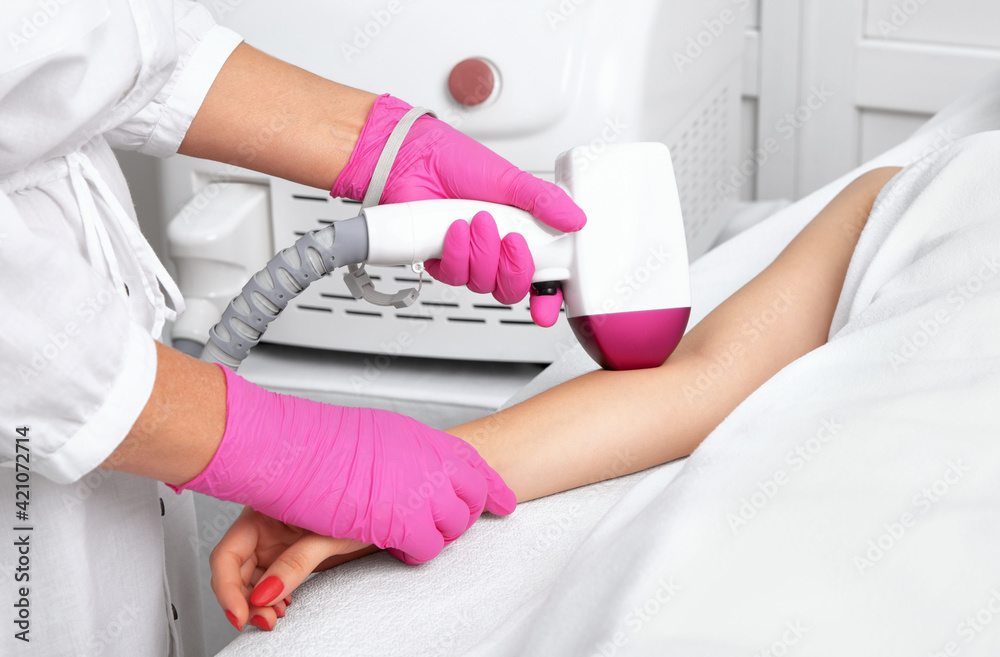 Elos epilation hair removal procedure on a womans body. Beautician doing laser rejuvenation on the hand in a beauty salon. Facial skin care. Hardware ipl cosmetology Elos epilation hair removal procedure on a womans body. Beautician doing laser rejuvenation on the hand in a beauty salon. Facial skin care. Hardware ipl cosmetology